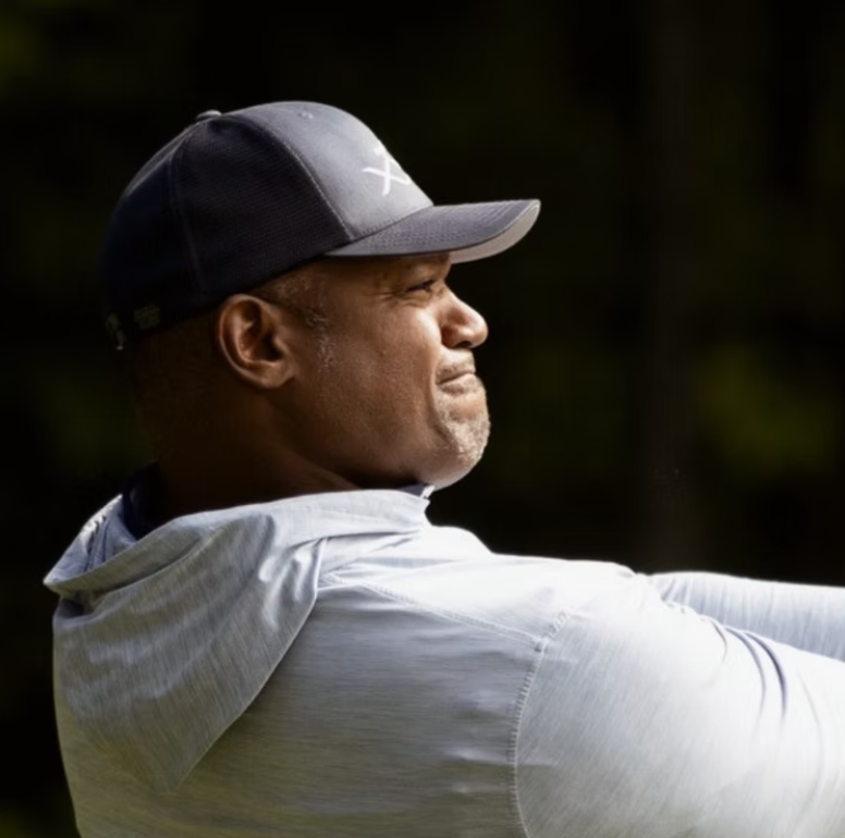 Dwight Freeney following through on a swing in a grey cap
